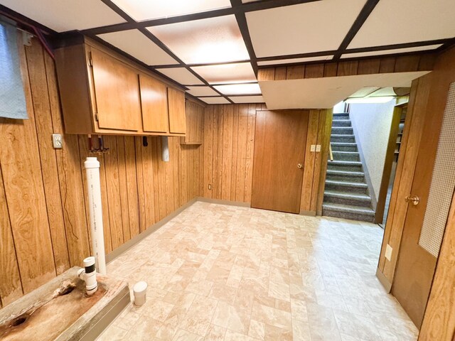 finished basement with wooden walls and stairway