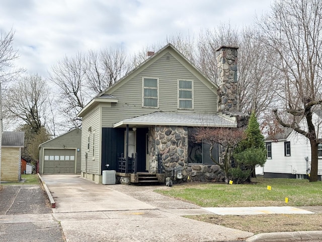 view of front of house featuring a chimney, an outdoor structure, concrete driveway, a detached garage, and cooling unit