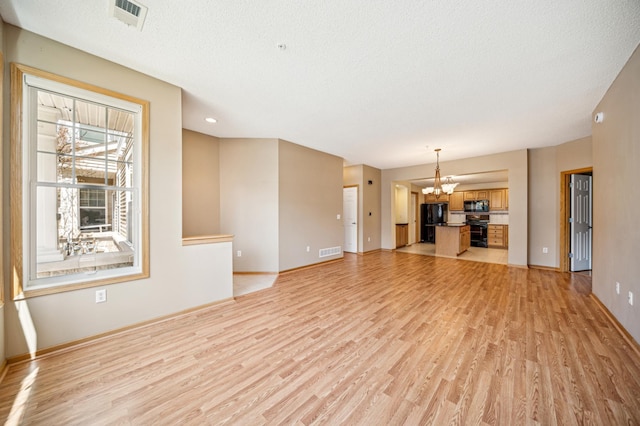 620 Wesley Commons Dr Unit 22, Golden Valley, MN 55427 - unfurnished living room with light wood-style flooring, a chandelier, baseboards, and a textured ceiling