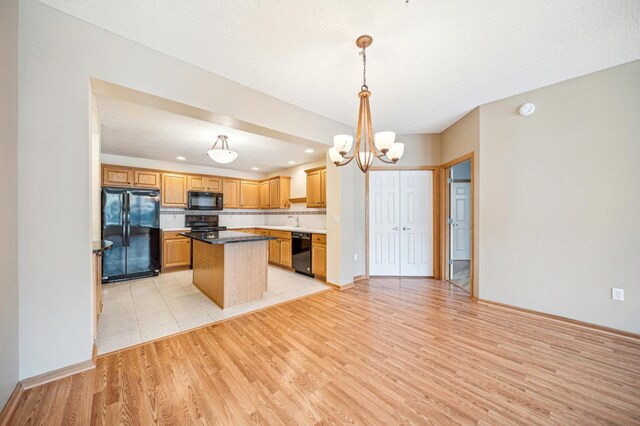 620 Wesley Commons Dr Unit 22, Golden Valley, MN 55427 - kitchen with black appliances, light wood-style flooring, a center island, a chandelier, and a sink