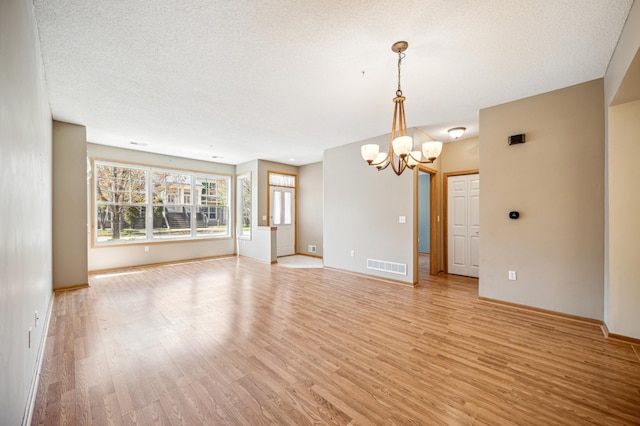 620 Wesley Commons Dr Unit 22, Golden Valley, MN 55427 - unfurnished room with a chandelier, light wood-style flooring, baseboards, and a textured ceiling