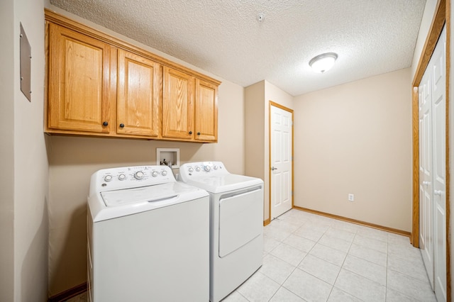 620 Wesley Commons Dr Unit 22, Golden Valley, MN 55427 - washroom featuring cabinet space, washer and clothes dryer, a textured ceiling, baseboards, and light tile patterned floors