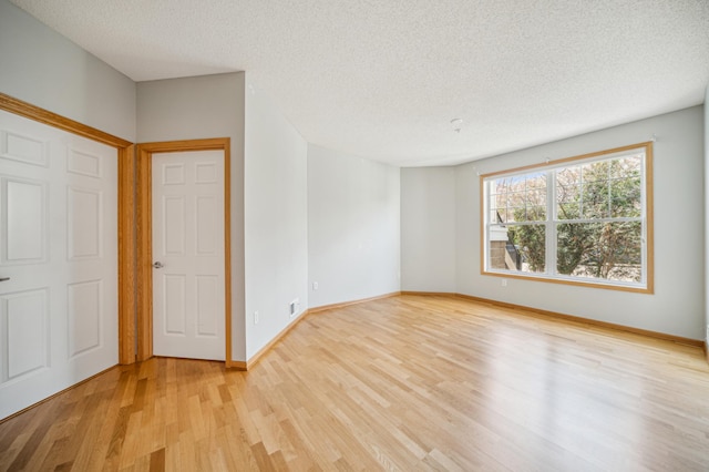 620 Wesley Commons Dr Unit 22, Golden Valley, MN 55427 - unfurnished bedroom featuring light wood-type flooring, a textured ceiling, and baseboards