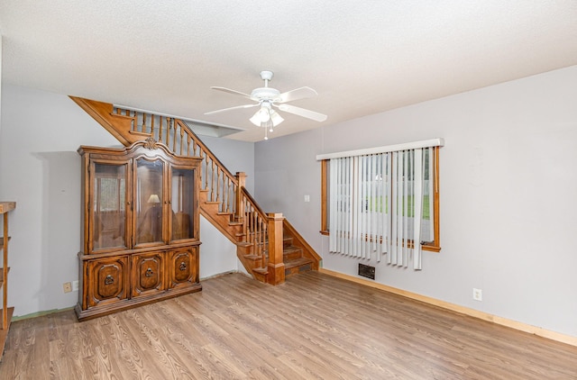 5870 Lynwood Blvd, Mound, MN 55364 - unfurnished living room with wood finished floors, a ceiling fan, and stairs