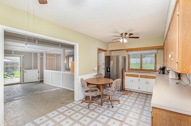 5870 Lynwood Blvd, Mound, MN 55364 - dining space with a ceiling fan, light flooring, healthy amount of natural light, a textured ceiling, and a wainscoted wall