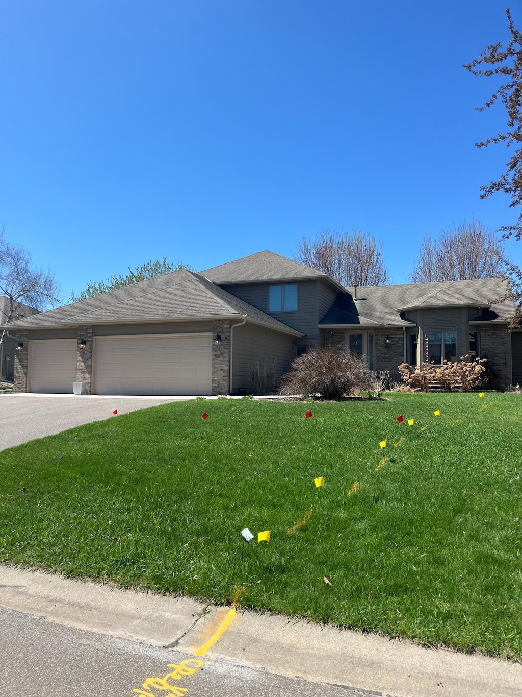 view of front of property with a garage, a front yard, and brick siding
