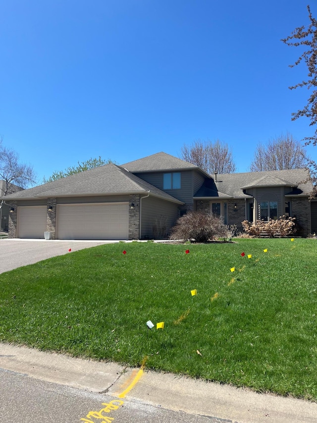 view of front of property with a garage, a front yard, and brick siding