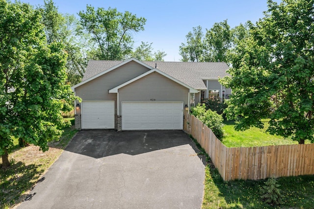 426 Dillon Ave N, Montrose, MN 55363 - view of front facade featuring driveway, roof with shingles, an attached garage, and fence