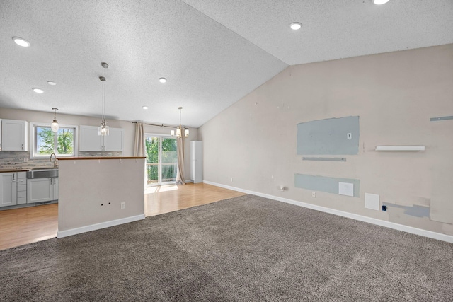 426 Dillon Ave N, Montrose, MN 55363 - unfurnished living room featuring light carpet, a textured ceiling, baseboards, recessed lighting, and a sink