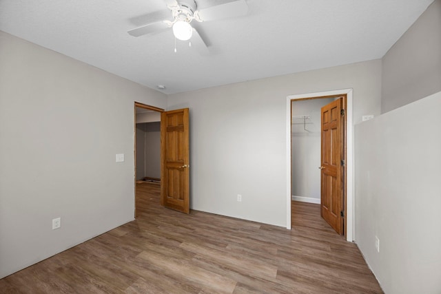 426 Dillon Ave N, Montrose, MN 55363 - unfurnished bedroom featuring a spacious closet, a closet, light wood finished floors, and a ceiling fan