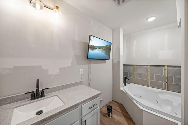 426 Dillon Ave N, Montrose, MN 55363 - bathroom featuring wood finished floors, a tub with jets, and vanity