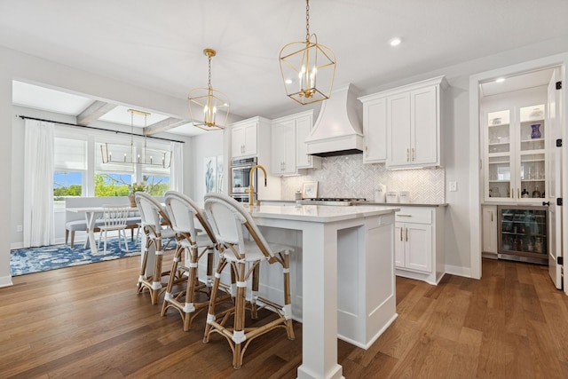 10859 23rd St NE, Saint Michael, MN 55376 - kitchen with beverage cooler, a chandelier, decorative backsplash, an island with sink, and a breakfast bar