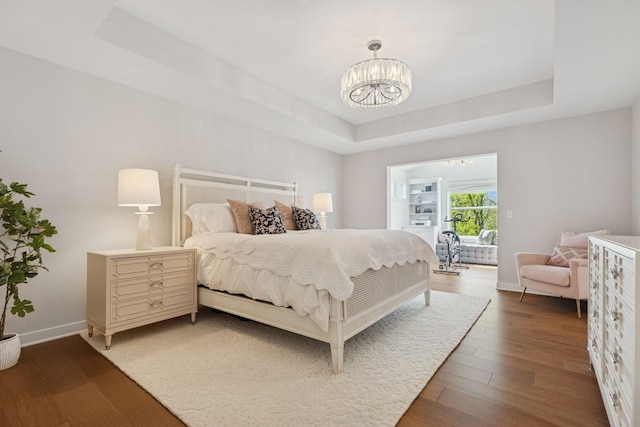 10859 23rd St NE, Saint Michael, MN 55376 - bedroom with a tray ceiling, a chandelier, wood finished floors, and baseboards