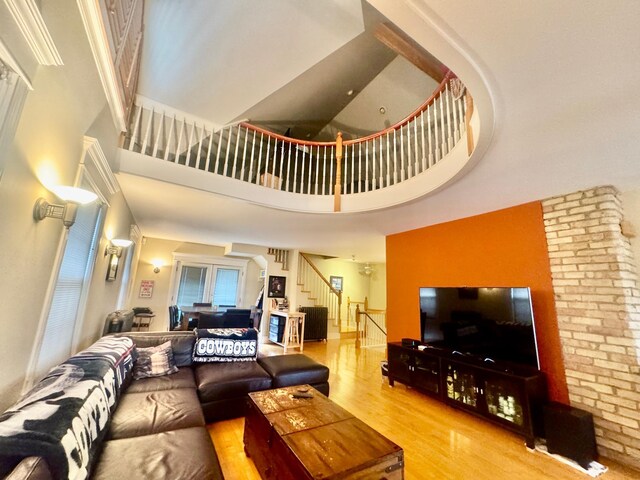 living area with stairway, a high ceiling, and wood finished floors