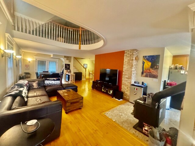 living area featuring stairway, hardwood / wood-style floors, and a towering ceiling