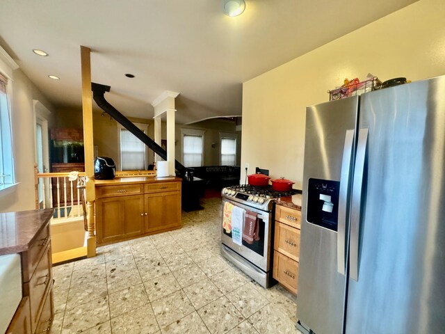 kitchen featuring brown cabinets, stainless steel appliances, dark countertops, and recessed lighting
