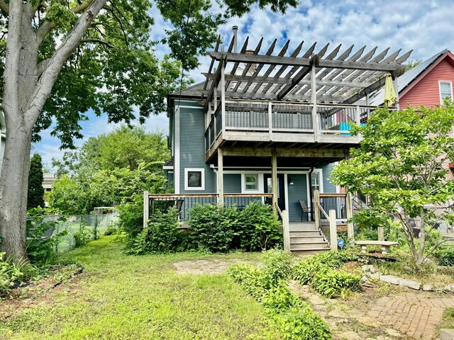 back of house featuring a lawn, a pergola, and fence