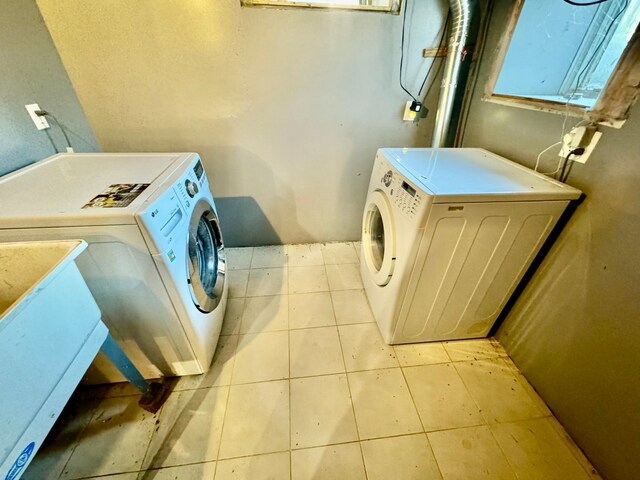 laundry room featuring laundry area, light tile patterned floors, and washing machine and dryer