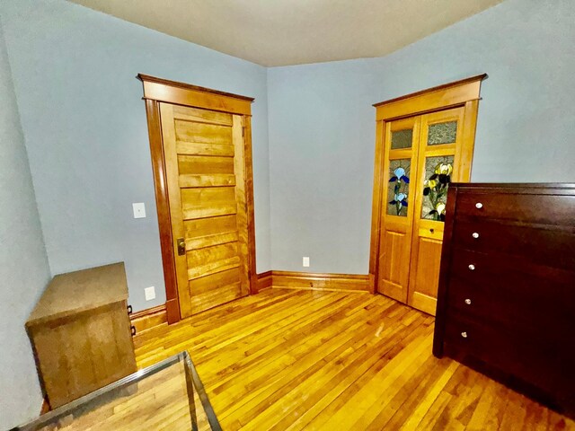 bedroom with baseboards and hardwood / wood-style flooring