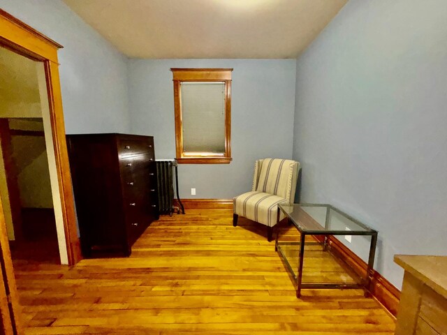 living area featuring baseboards and hardwood / wood-style flooring
