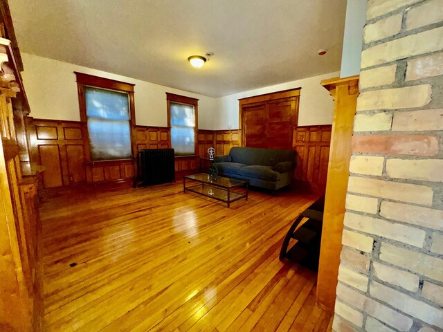 sitting room featuring radiator, a wainscoted wall, and hardwood / wood-style floors