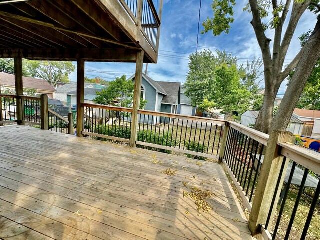 wooden deck with a residential view, a storage unit, an outdoor structure, and fence