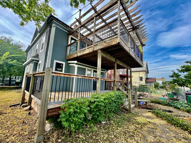 view of side of property featuring fence and a deck