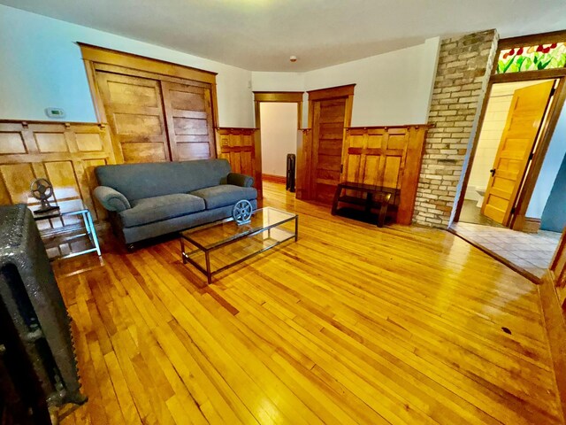 living area featuring light wood-style floors and a wainscoted wall