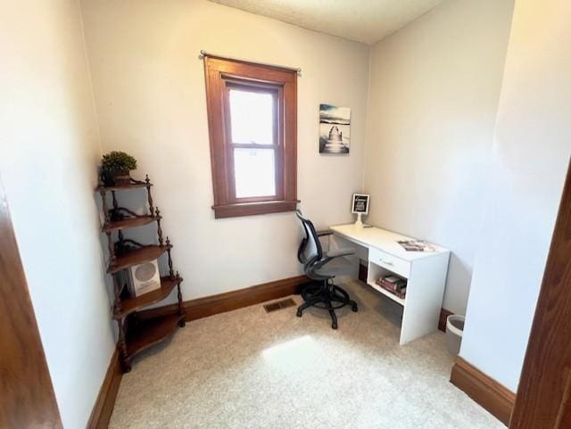 office space featuring baseboards, light carpet, and visible vents