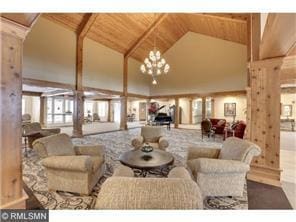 interior space with ornate columns, vaulted ceiling, a chandelier, and wood ceiling