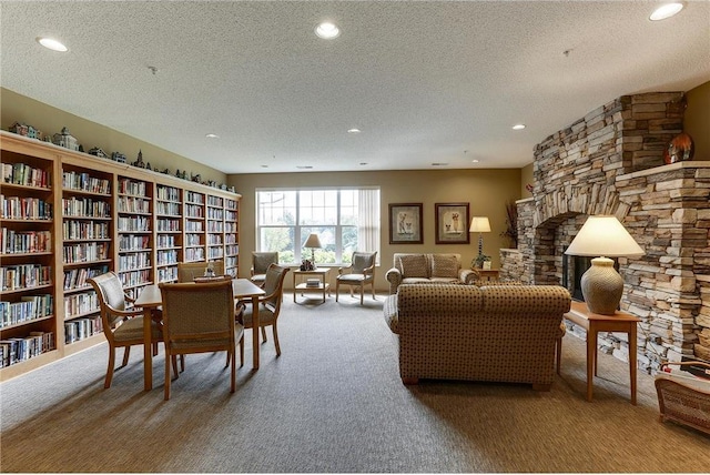 living room with recessed lighting, a textured ceiling, carpet flooring, and wall of books