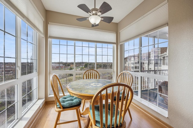 sunroom with a textured wall, wood finished floors, and a healthy amount of sunlight
