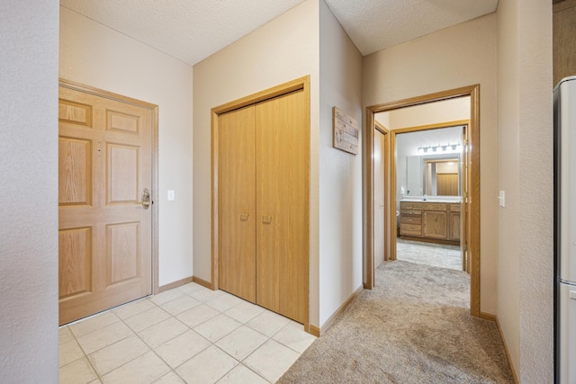 corridor featuring a textured ceiling and baseboards
