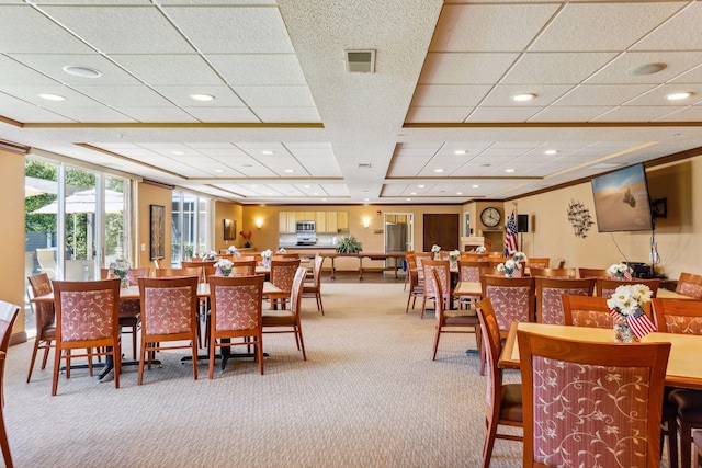 carpeted dining area featuring visible vents, recessed lighting, crown molding, and a paneled ceiling
