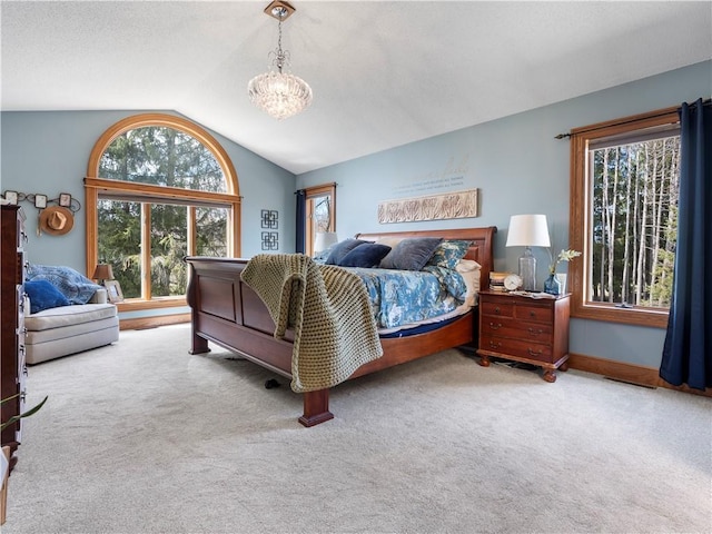carpeted bedroom featuring a notable chandelier and lofted ceiling
