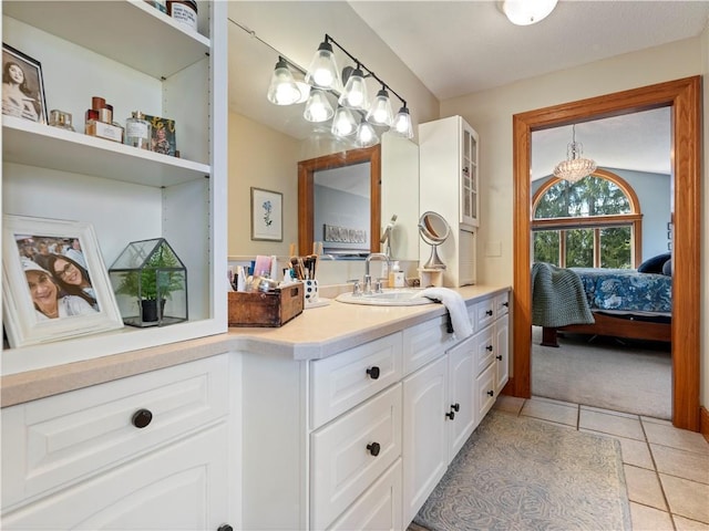 ensuite bathroom featuring vanity, an inviting chandelier, tile patterned floors, and ensuite bathroom