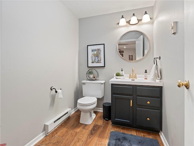half bath with wood finished floors, a baseboard radiator, toilet, vanity, and baseboards