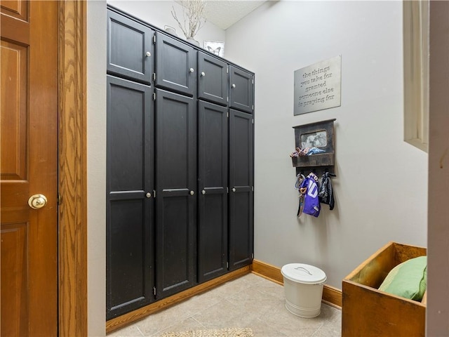 interior space featuring light tile patterned floors and baseboards