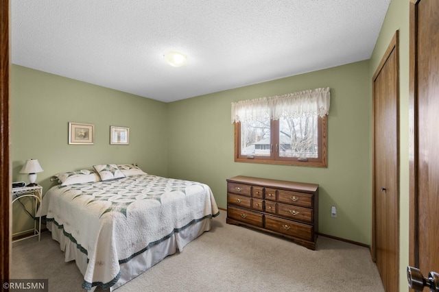 bedroom featuring a textured ceiling, a closet, carpet floors, and baseboards