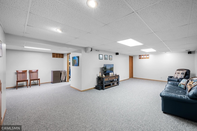 living room featuring carpet, a drop ceiling, and baseboards