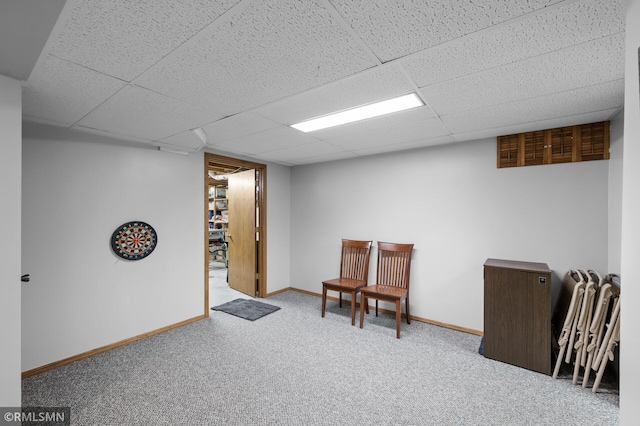 finished below grade area featuring baseboards, carpet, and a paneled ceiling