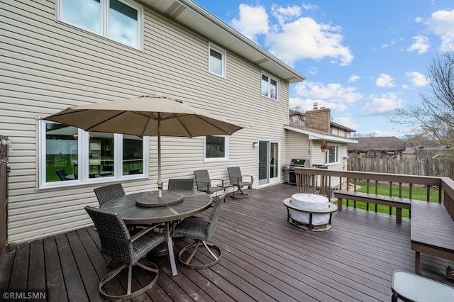 deck with a grill, fence, and outdoor dining area