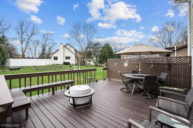 wooden deck with fence, outdoor dining area, and a yard