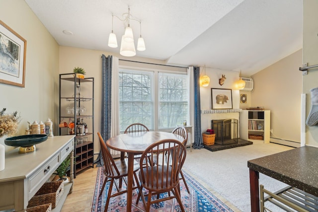 4654 Cedar Lake Rd S Unit 6, Saint Louis Park, MN 55416 - dining space with a notable chandelier, baseboard heating, a fireplace, vaulted ceiling, and a wall mounted AC