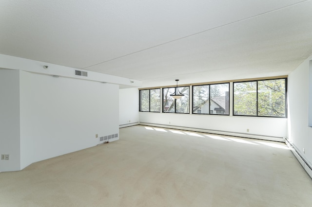 empty room with light carpet and a baseboard heating unit