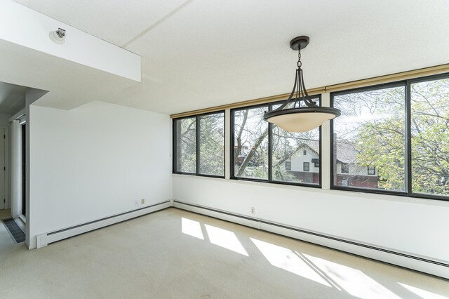 unfurnished dining area featuring a baseboard radiator and carpet