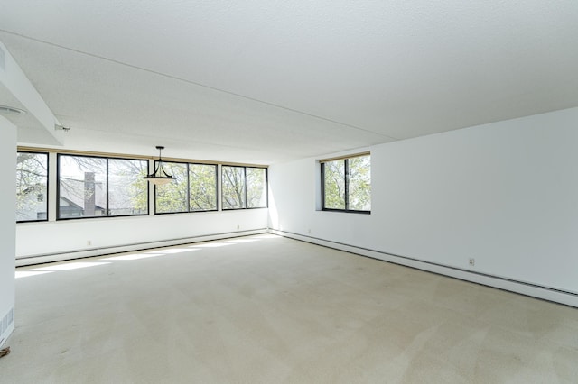 empty room featuring carpet flooring and a baseboard heating unit