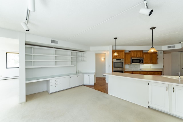 kitchen featuring appliances with stainless steel finishes, open shelves, track lighting, light countertops, and carpet flooring