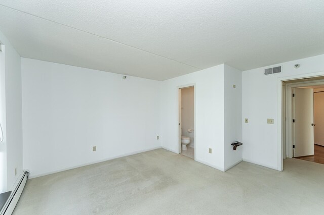 unfurnished room featuring baseboard heating and light colored carpet