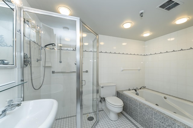 bathroom with a sink, tile walls, tile patterned floors, toilet, and a shower stall